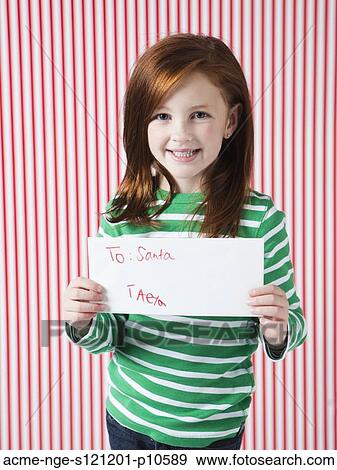Stock Photo - Studio portrait of girl (4-5) holding letter to Santa. Fotosearch