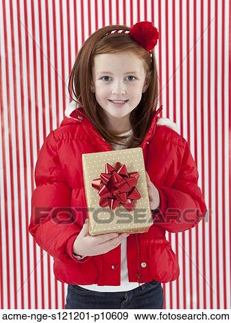 Studio portrait of girl (4-5) holding of Christmas gift View Large Photo Image Stock Photo - Studio portrait of girl (4-5) holding of Christmas gift. Fotosearch