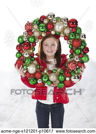 Studio portrait of girl (4-5) holding Christmas decoration View Large Photo Image Stock Photo - Studio portrait of girl (4-5) holding Christmas decoration. Fotosearch
