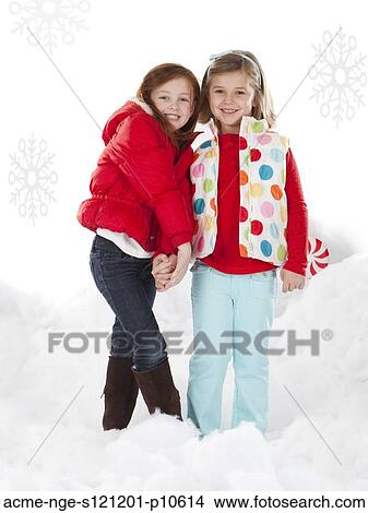 Picture - Studio portrait of girls (4-5, 6-7) standing in snow. Fotosearch