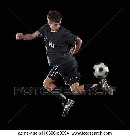 Picture - Studio portrait of teenage boy (16-17) with soccer ball. Fotosearch