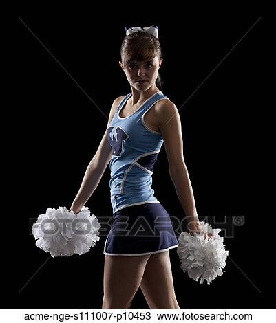 Stock Image - Studio shot of cheerleader (16-17) striking pose. Fotosearch