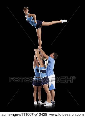 Studio shot of cheerleaders (16-17) supporting friend standing on one leg View Large Photo Image Stock Photo - Studio shot of cheerleaders (16-17) supporting friend standing on one leg. Fotosearch