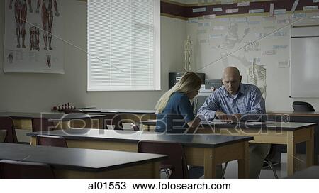 Teacher instructing and tutoring student in classroom View Large Photo Image Stock Image - Teacher instructing and tutoring student in classroom. Fotosearch