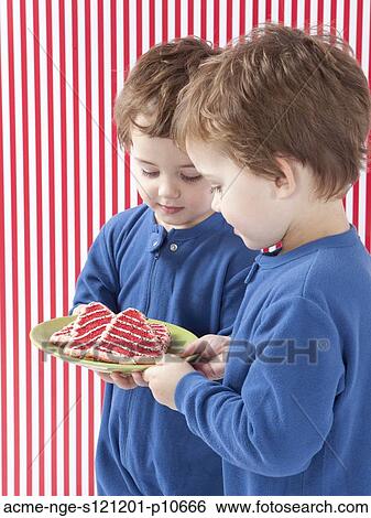 Twin boys (2-3) wearing pajamas holding gingerbreads View Large Photo Image Stock Photograph - Twin boys (2-3) wearing pajamas holding gingerbreads. Fotosearch