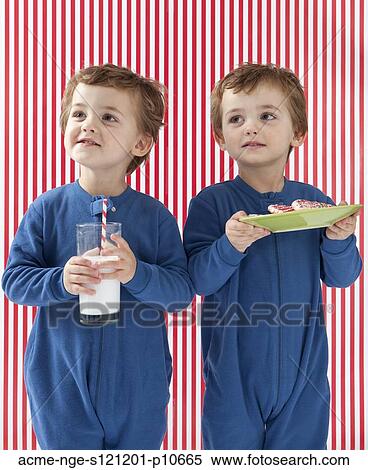Twin boys (2-3) wearing pajamas holding gingerbreads and glass of milk View Large Photo Image Stock Photography - Twin boys (2-3) wearing pajamas holding gingerbreads and glass of milk. Fotosearch