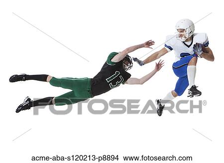 Two male players of American football fighting for ball, studio shot View Large Photo Image Picture - Two male players of American football fighting for ball, studio shot. Fotosearch