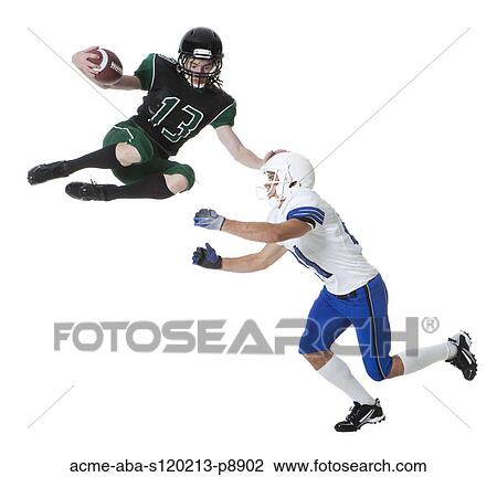 Stock Image - Two male players of American football fighting for ball, studio shot. Fotosearch
