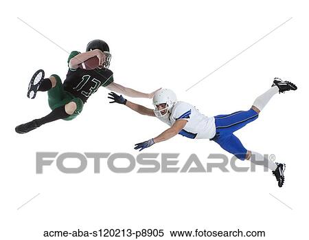 Stock Photography - Two male players of American football fighting for ball, studio shot. Fotosearch