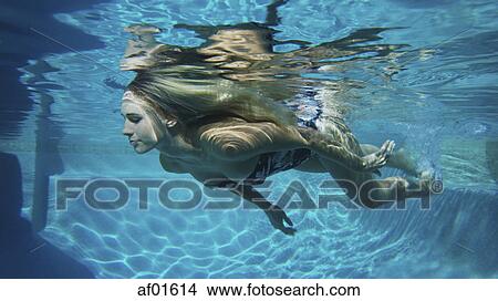 Underwater view of woman in bikini swimming in pool View Large Photo Image Picture - Underwater view of woman in bikini swimming in pool. Fotosearch