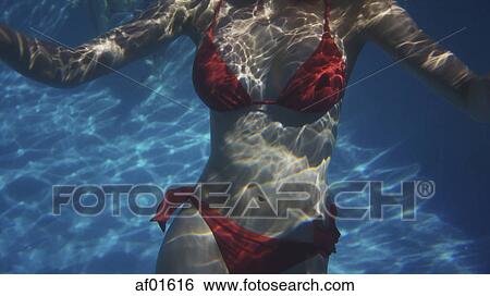 Underwater view of woman in bikini swimming in pool View Large Photo Image Stock Photograph - Underwater view of woman in bikini swimming in pool. Fotosearch