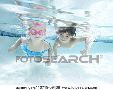 Stock Photo - USA, Utah, Orem, Boy (4-5) and girl (2-3) swimming in pool. Fotosearch