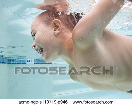 Stock Image - USA, Utah, Orem, Boy (6-7) swimming in pool. Fotosearch