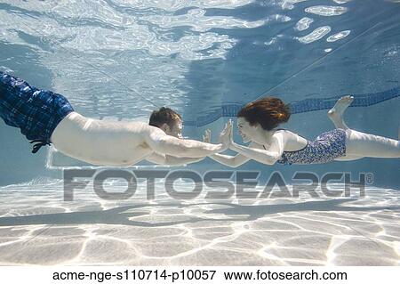 USA, Utah, Orem, Happy young couple holding hands in swimming pool View Large Photo Image Stock Photo - USA, Utah, Orem, Happy young couple holding hands in swimming pool. Fotosearch