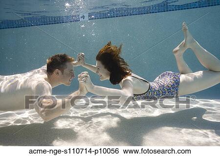 USA, Utah, Orem, Happy young couple holding hands in swimming pool View Large Photo Image Stock Photograph - USA, Utah, Orem, Happy young couple holding hands in swimming pool. Fotosearch