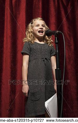Stock Photo - USA, Utah, Orem, Portrait of girl (8-9) singing with microphone. Fotosearch