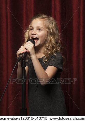 Stock Photography - USA, Utah, Orem, Portrait of girl (8-9) singing with microphone. Fotosearch