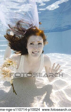 Picture - USA, Utah, Orem, Portrait of young bride with bouquet under water. Fotosearch