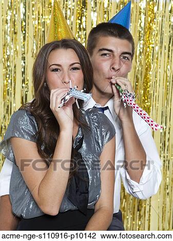 USA, Utah, Orem, Portrait of young couple blowing horns at party View Large Photo Image Stock Image - USA, Utah, Orem, Portrait of young couple blowing horns at party. Fotosearch