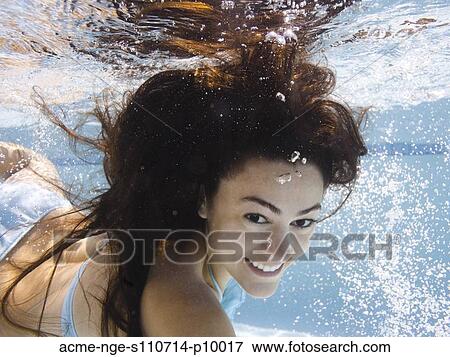 Stock Photo - USA, Utah, Orem, Portrait of young woman under water. Fotosearch