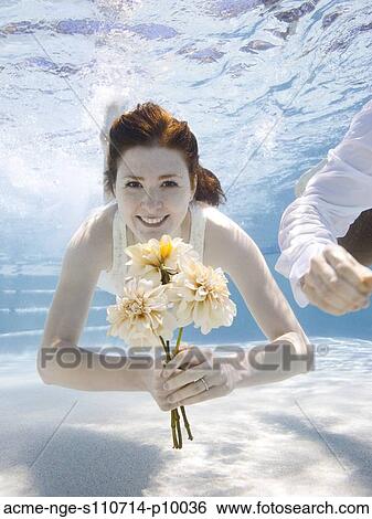 USA, Utah, Orem, Portrait of young woman with bouquet under water View Large Photo Image Stock Photograph - USA, Utah, Orem, Portrait of young woman with bouquet under water. Fotosearch