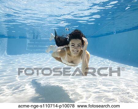 Stock Photo - USA, Utah, Orem, Smiling woman swimming in swimming pool. Fotosearch