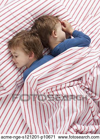 USA, Utah, Orem, Twin boys (2-3) wearing pajamas lying on bed View Large Photo Image Stock Image - USA, Utah, Orem, Twin boys (2-3) wearing pajamas lying on bed. Fotosearch