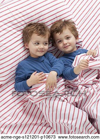 USA, Utah, Orem, Twin boys (2-3) wearing pajamas playing on bed View Large Photo Image Stock Image - USA, Utah, Orem, Twin boys (2-3) wearing pajamas playing on bed. Fotosearch