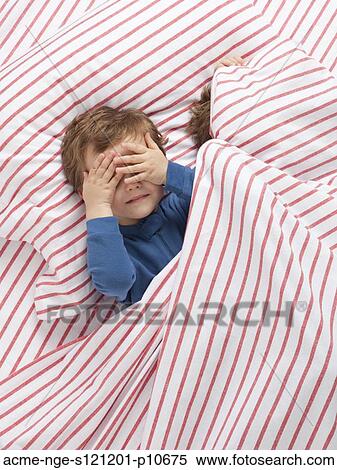 Stock Photography - USA, Utah, Orem, Twin boys (2-3) wearing pajamas playing on bed. Fotosearch