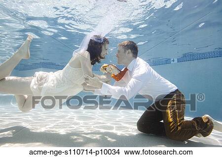 Picture - USA, Utah, Orem, Wedding couple under water. Fotosearch