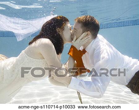 Stock Image - USA, Utah, Orem, Wedding couple under water. Fotosearch