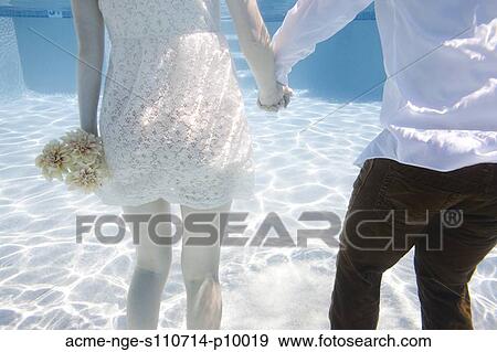 Stock Photo - USA, Utah, Orem, Wedding couple under water. Fotosearch