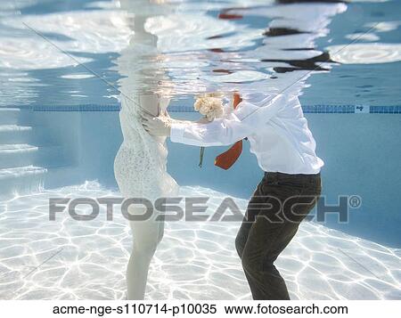 Stock Photography - USA, Utah, Orem, Wedding couple under water. Fotosearch