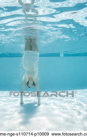 Stock Photo - USA, Utah, Orem, Woman doing handstand under water. Fotosearch