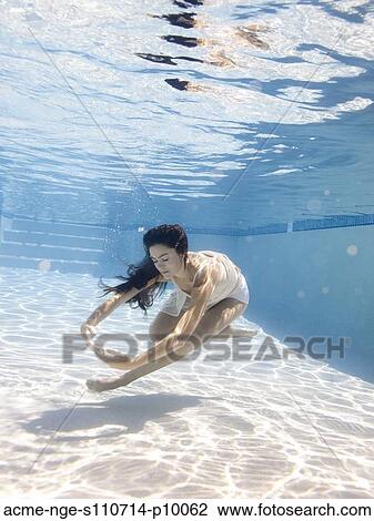 Stock Image - USA, Utah, Orem, Young woman in pool ballet dancing. Fotosearch