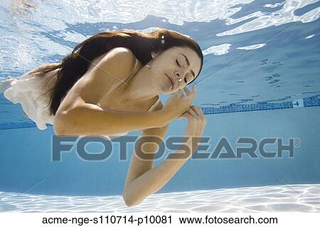 Stock Image - USA, Utah, Orem, Young woman in pool ballet dancing. Fotosearch