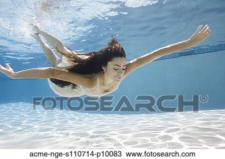 Stock Image - USA, Utah, Orem, Young woman in pool ballet dancing. Fotosearch