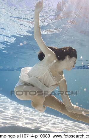 Stock Photo - USA, Utah, Orem, Young woman in pool ballet dancing. Fotosearch