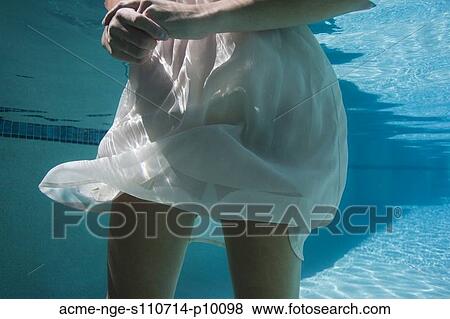 Stock Photo - USA, Utah, Orem, Young woman in pool ballet dancing. Fotosearch