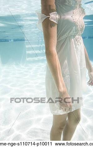 Stock Image - USA, Utah, Orem, Young woman standing under water. Fotosearch