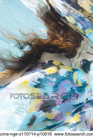 Stock Photograph - USA, Utah, Orem, Young woman under water wrapped in colorful textile. Fotosearch