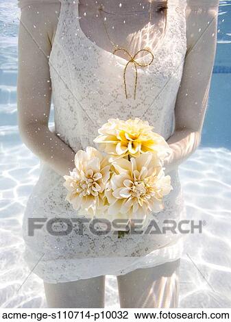 Stock Image - USA, Utah, Orem, Young woman with bouquet under water. Fotosearch