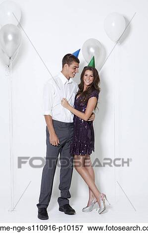 Stock Photo - Young couple embracing at party. Fotosearch