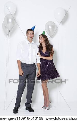 Young couple smiling among balloons at party View Large Photo Image Stock Photo - Young couple smiling among balloons at party. Fotosearch