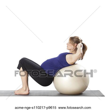 Young pregnant woman exercising with fitness ball, studio shot View Large Photo Image Stock Photography - Young pregnant woman exercising with fitness ball, studio shot. Fotosearch