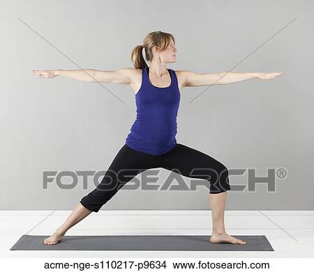 Picture - Young pregnant woman practicing yoga, studio shot. Fotosearch