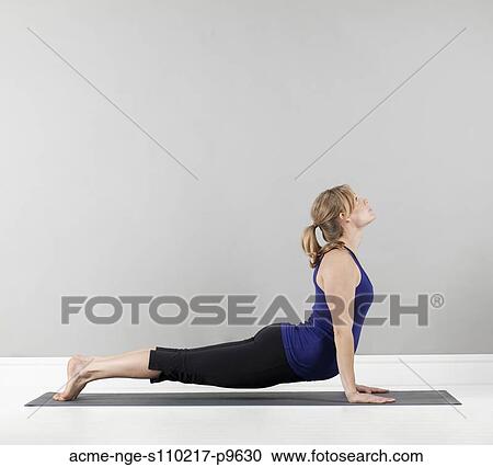 Stock Image - Young pregnant woman practicing yoga, studio shot. Fotosearch