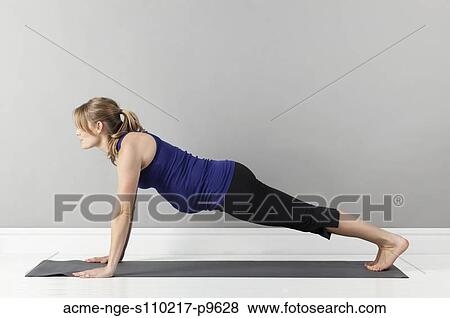 Stock Photo - Young pregnant woman practicing yoga, studio shot. Fotosearch