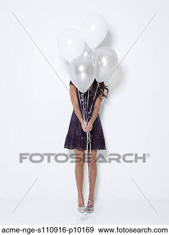 Young woman hiding behind balloons at party View Large Photo Image Stock Photo - Young woman hiding behind balloons at party. Fotosearch