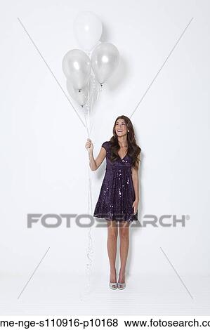 Young woman holding balloons at party View Large Photo Image Stock Photo - Young woman holding balloons at party. Fotosearch